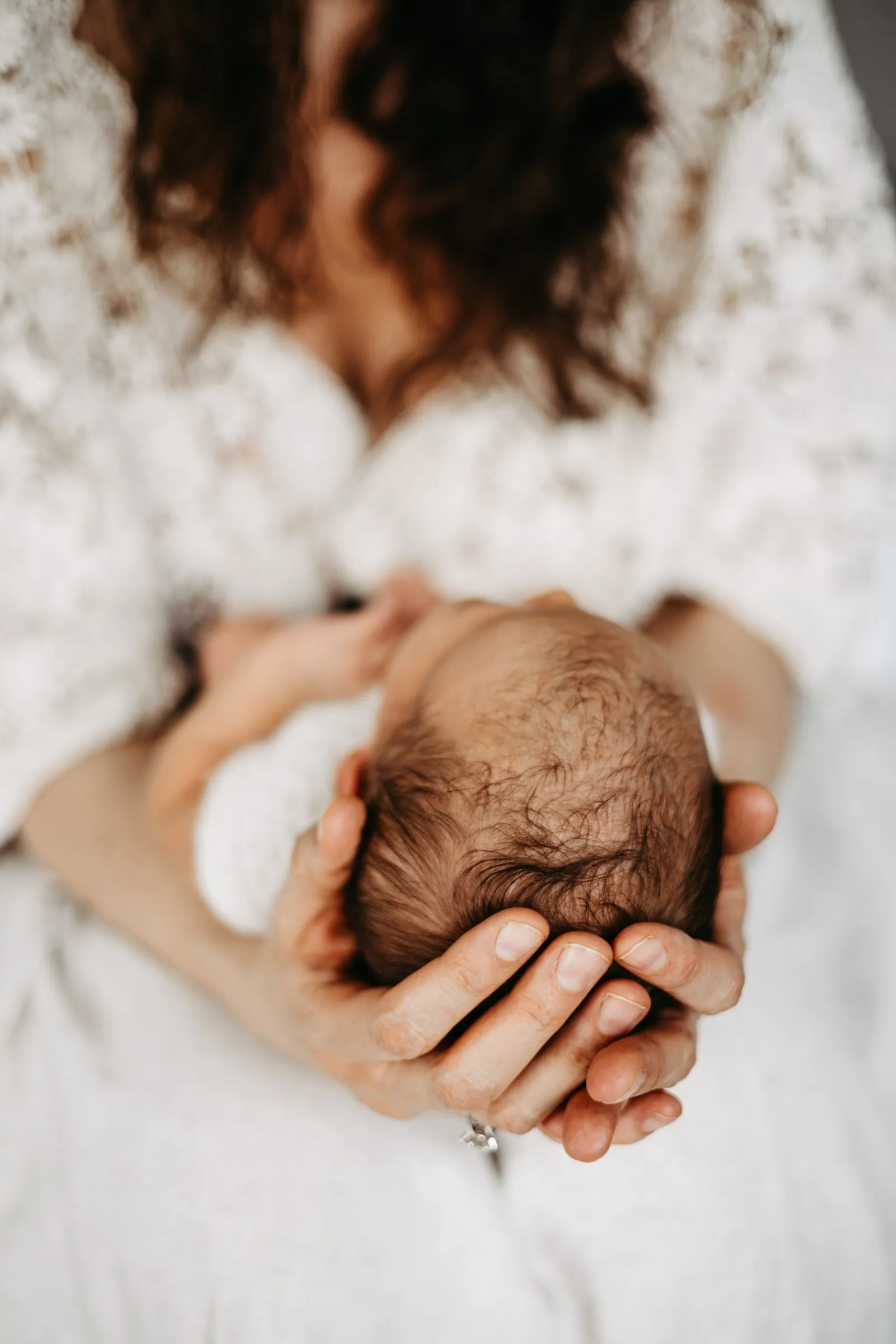 Aus Marias Familienfotografie: Eine Mutter hält ihr Neugeborenes behutsam im Arm