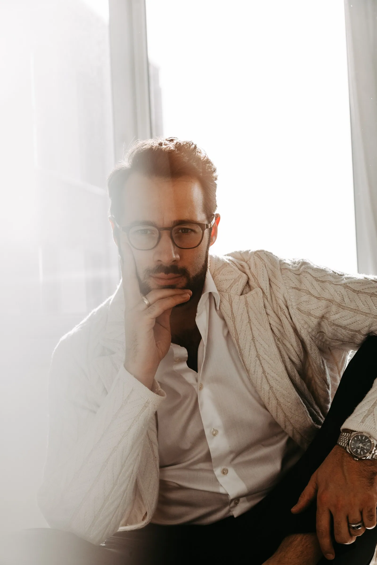 Businessportrait eines Mannes mit Brille am hellen Fenster